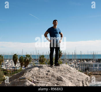 Giovane uomo in piedi sulle rocce in Spagna Garaff affacciata sul Mediterraneo Foto Stock