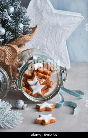 Sfondo di natale in verde e blu con la stella di gustosi biscotti allo zenzero in un vasetto di vetro con decorate albero di Natale Foto Stock