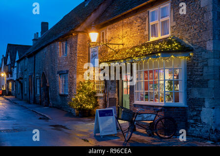 Lacock forno del paese di notte con un albero di natale e decorazioni. Lacock, Cotswolds, Wiltshire, Inghilterra Foto Stock