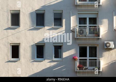 Blocco di appartamenti facciata nel sole del mattino con le unità aria condizionata montato sulla parete, piccoli balconi in Budapest, Ungheria. Foto Stock