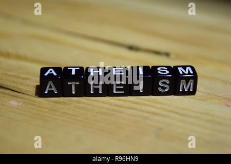L ateismo scritto su blocchi di legno. Ispirazione e motivazione concetti. Croce immagine elaborata su sfondo di legno Foto Stock