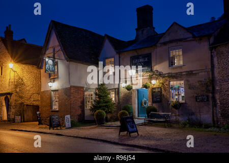 Il George Inn di notte con un albero di natale. Lacock, Cotswolds, Wiltshire, Inghilterra Foto Stock