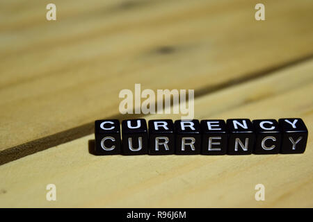 Valuta scritto su blocchi di legno. Ispirazione e motivazione concetti. Croce immagine elaborata su sfondo di legno Foto Stock