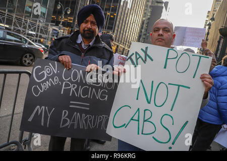 New York, NY 12/19/2018: Giallo e verde della cabina Rally tenutasi oggi di fronte al Gov. Cuomo's Midtown office. Circa 60 persone dove raccolti. Parlare fuori contro lo stato del nuovo supplemento per viaggi in Manhattan. La misura, parte di un più ampio di attribuzione di prezzi per la congestione di proposta, permetterà di aggiungere sovrapprezzi per qualsiasi yellow cab, e-grandine o altro per-noleggio veicolo viaggi che avvia, passano attraverso o alla fine di un designato "congestion zone" sotto la 96esima strada a Manhattan inizio 1 gennaio. Credito: SCOOTERCASTER/Alamy Live News Foto Stock