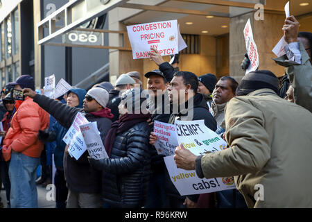 New York, NY 12/19/2018: Giallo e verde della cabina Rally tenutasi oggi di fronte al Gov. Cuomo's Midtown office. Circa 60 persone dove raccolti. Parlare fuori contro lo stato del nuovo supplemento per viaggi in Manhattan. La misura, parte di un più ampio di attribuzione di prezzi per la congestione di proposta, permetterà di aggiungere sovrapprezzi per qualsiasi yellow cab, e-grandine o altro per-noleggio veicolo viaggi che avvia, passano attraverso o alla fine di un designato "congestion zone" sotto la 96esima strada a Manhattan inizio 1 gennaio. Credito: SCOOTERCASTER/Alamy Live News Foto Stock