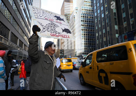 New York, NY 12/19/2018: Giallo e verde della cabina Rally tenutasi oggi di fronte al Gov. Cuomo's Midtown office. Circa 60 persone dove raccolti. Parlare fuori contro lo stato del nuovo supplemento per viaggi in Manhattan. La misura, parte di un più ampio di attribuzione di prezzi per la congestione di proposta, permetterà di aggiungere sovrapprezzi per qualsiasi yellow cab, e-grandine o altro per-noleggio veicolo viaggi che avvia, passano attraverso o alla fine di un designato "congestion zone" sotto la 96esima strada a Manhattan inizio 1 gennaio. Credito: SCOOTERCASTER/Alamy Live News Foto Stock