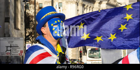 Un anti-Brexit dimostrante è visto indossare un colore dell'UE la maschera per il viso accanto a una bandiera dell'Unione europea fuori le case del Parlamento. Con soli 100 giorni per andare fino a Brexit, il governo del Regno Unito ha stanziato 2 miliardi di sterline per un 'No Deal' Brexit. Foto Stock