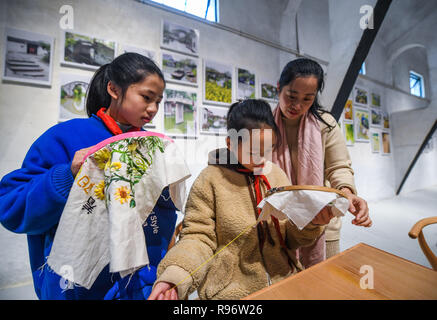 Huzhou, cinese della Provincia di Zhejiang. Xx Dec, 2018. Gli studenti imparano a fare ricami tradizionale presso il book bar di una cultura e di un centro sportivo in Yangxiji township di Huzhou City, est della Cina di Provincia dello Zhejiang, Dic 20, 2018. Tre granai obsoleti con 50 anni di storia sono state trasformate in una cultura e centro sportivo durante un completo ambiente di campagna di miglioramento in Yangxiji Township. La cultura e il centro sportivo che consiste di cinema, piscina palestra e prenota bar è diventato il nuovo punto di riferimento nelle township. Credito: Xu Yu/Xinhua/Alamy Live News Foto Stock