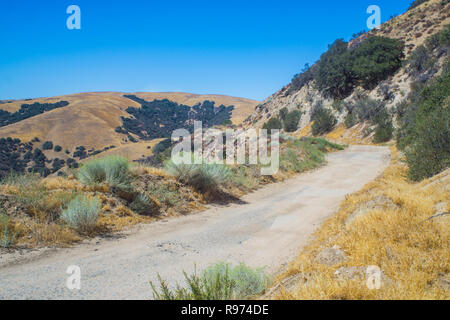 La sporcizia e la strada sterrata che conduce attraverso il deserto di montagna del sud della California al di fuori di Los Angeles. Foto Stock