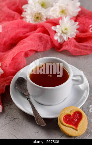 Una tazza di tè e biscotti con cuori. Bella la vita ancora con una tazza di tè, l'umore del giorno di San Valentino. Close-up. Foto Stock