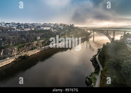 Vista in lontananza la D. Maria Pia e Sao Joao ponti, a Porto in Portogallo durante le ore del mattino. Cielo nuvoloso. Foto Stock