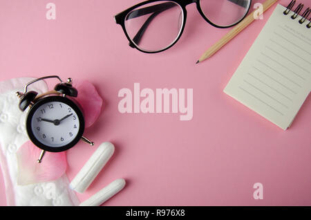 Donne hyhienic ciclo di tamponi e assorbenti interni su sfondo rosa. Copia dello spazio. Foto Stock