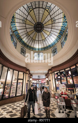 Una coppia con il loro shopping di natale sotto la cupola di Roses nel Passage des Princes, Parigi, 2018 dicembre 15 Foto Stock