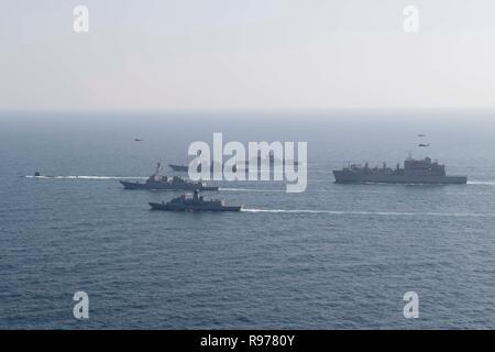 Da sinistra, l'attacco rapido sommergibile USS Louisville (SSN 724), la visita-missile destroyer USS Spruance (DDG 111), il Royal Australian navy fregata HMAS Ballarat (FFH 155), la visita-missile destroyer USS Stockdale (DDG 106), la marina francese Air Defense destroyer FS Cassard (D 614), e il trasporto di carichi secchi e munizioni nave USNS Richard E. Byrd (T-AKE 4) vele in formazione durante l'anti-guerra sottomarina esercizio SHAREM 195 nel Mare Arabico, Dic 18, 2018. Stockdale e Spruance sono distribuiti negli Stati Uniti Quinta Flotta area di operazioni a sostegno di operazioni navali per garantire stabilità marittima Foto Stock