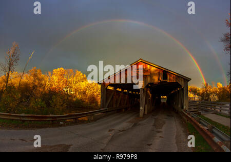 Rainbow oltre il mulino di polpa Bridge, un ponte coperto che copre oltre Otter Creek a Middlebury, Vermont. Foto Stock