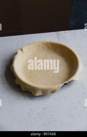 Materie non cotti base di pastafrolla per torta in teglia su sfondo di calcestruzzo Foto Stock