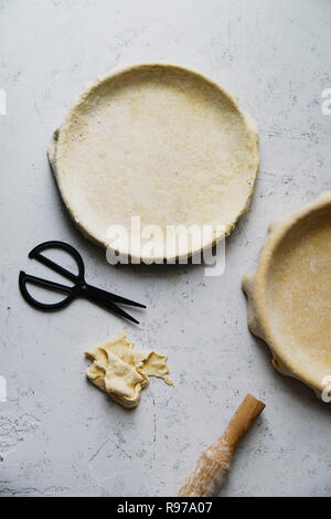 Materie non cotti base di pastafrolla per torta in teglia per torte di due su sfondo di calcestruzzo Foto Stock