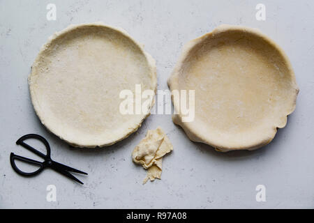 Materie non cotti base di pastafrolla per torta in teglia per torte di due su sfondo di calcestruzzo Foto Stock