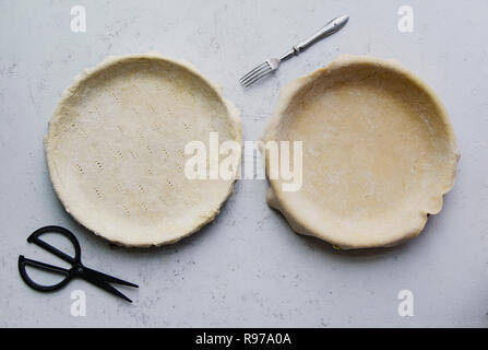 Materie non cotti base di pastafrolla per torta in teglia per torte di due su sfondo di calcestruzzo Foto Stock