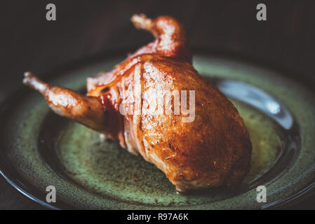 Quaglie al forno avvolto in pancetta sulla piastra Foto Stock