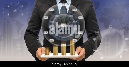 Imprenditore della pasticca con la terra e la pila di monete d'oro sul trading grafico sul paesaggio urbano e la mappa del mondo sfondo,elementi di questa immagine Foto Stock