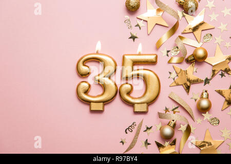 Numero 35 celebrazione oro candela su stella e glitter sfondo Foto Stock