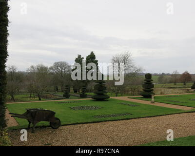 I motivi della proprietà del National Trust a Canons Ashby, Northamptonshire su un livello di grigio dicembre pomeriggio; vista di prati, topiaria da campagna e Foto Stock