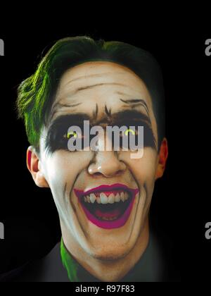 Sanguinosi tema Halloween: il folle Joker Face su sfondo nero ridendo nel buio. Vacanze di Halloween. Foto Stock