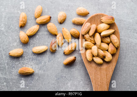 Il salato mandorle tostate in cucchiaio di legno. Foto Stock