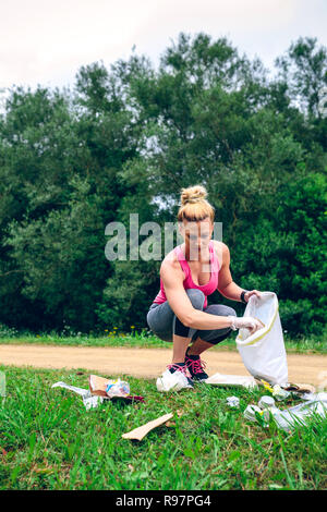 Ragazza di prelevare il cestino facendo plogging Foto Stock