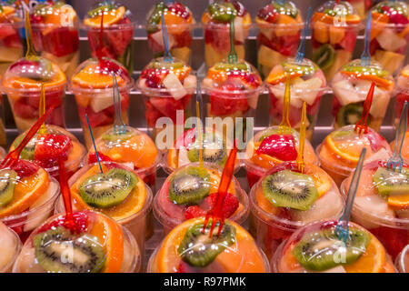 Vari tipi di frutta fresca in bicchieri di plastica per la preparazione di bevande frullato. Fruttato colorati drink e bevande. Foto Stock