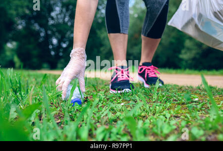 Plogging. Ragazza raccolta a mano l'Immondizia Foto Stock