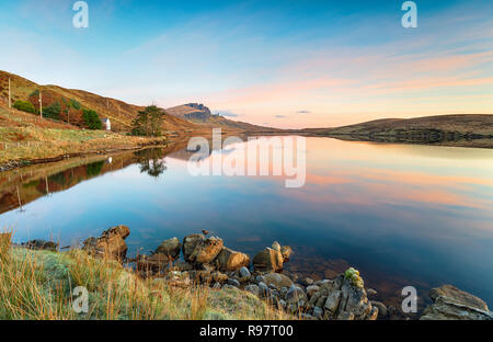 Sunrise a Loch Fada sull'Isola di Skye con il vecchio uomo di Storr a distanza Foto Stock