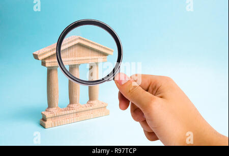 Lente di ingrandimento è guardare il monumento in legno o palazzo del governo. Rappresentazione minimalista di un statebuilding , un tribunale o di un monumento Foto Stock