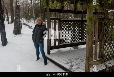 Donna asiatica con biege knit hat in piedi nella neve Foto Stock