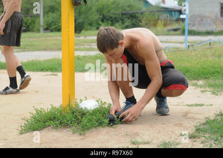 Kovrov, Russia. 21 luglio 2013. Teen set di casse di piccole dimensioni durante impegnato nella disciplina gimbarr su una barra orizzontale nella schoolyard Foto Stock