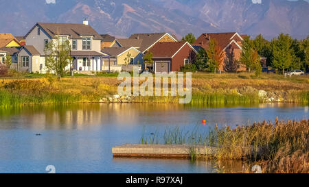 Vista panoramica con le abitazioni nei pressi del lago contro la montagna Foto Stock