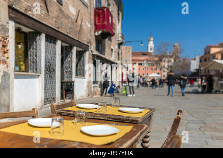 Vecchi tavoli di legno in accoglienti outdoor cafe a Venezia, Italia Foto Stock