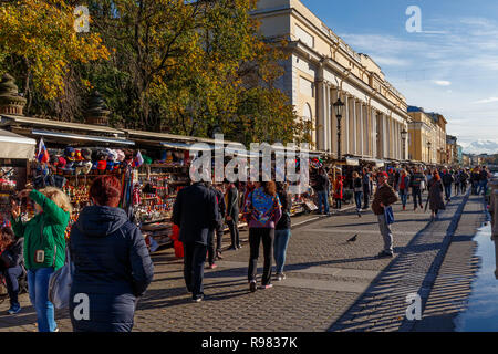 Waterside turisti in autunno al sole con souvenier va in stallo al di fuori della Chiesa del Salvatore sul Sangue versato, San Pietroburgo, Russia. Foto Stock