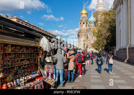 Waterside turisti in autunno al sole con souvenier va in stallo al di fuori della Chiesa del Salvatore sul Sangue versato, San Pietroburgo, Russia. Foto Stock