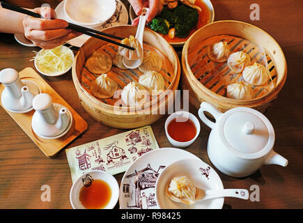 La carne di maiale-riempita bun al vapore gnocchi (dim sum) nel famoso Nanxiang Steamed Bun Ristorante nella città vecchia di Shanghai. Foto Stock