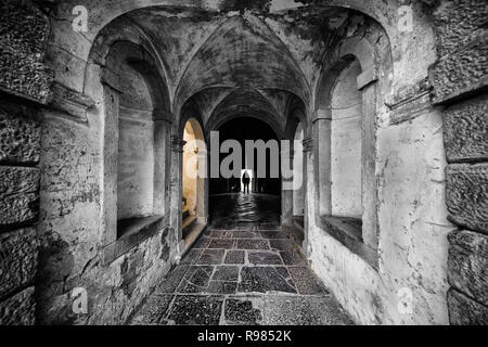 Uomo in piedi nella luce di una apertura porta in una casa medievale in Velike Zablje, Slovenia Foto Stock