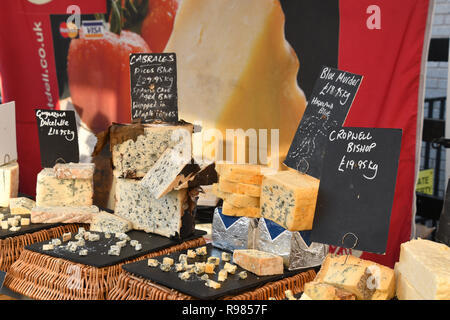 Formaggi sul mercato in stallo Somerset visualizzati con i campioni per la degustazione.Cabrales Picos blu,Blue omicidio e Cropwell vescovo. Inghilterra, Regno Unito Foto Stock