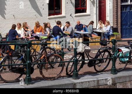 I giovani al di fuori seduta Festina Lente cafe a Amsterdam, Paesi Bassi Foto Stock