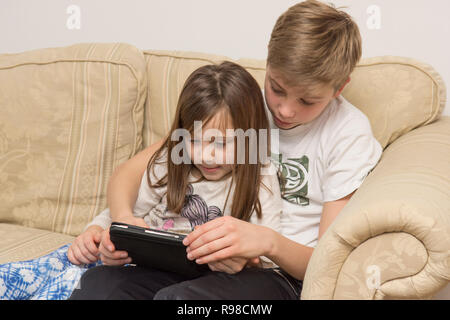 Dispositivo digitale, tablet, iPad fratello aiutando sorella più giovane con i social media, tecnologia moderna Foto Stock