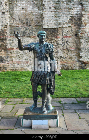 La statua dell'Imperatore Traiano, al di fuori di una sezione del muro romano a Tower Hill, London REGNO UNITO Foto Stock