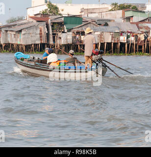 Tre turisti maschio essendo presa dal piccolo motoscafo per visitare il famoso Cai Rang mercato galleggiante, Cai Rang Fiume,Can Tho Provincia, Vietnam Foto Stock