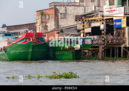 Tradizionale vietnamita cargo barche attraccate al dock del Cai Rang fiume adiacente a Cai Rang mercato galleggiante, Can Tho Provincia, Vietnam Foto Stock