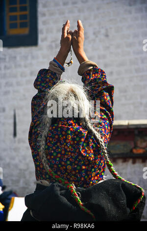 Lhasa, regione autonoma del Tibet, Cina : Una vecchia donna tibetano prega al di fuori il tempio del Jokhang in Barkhor Square. Il Jokhang è considerato come il più Foto Stock