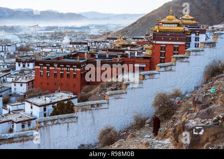 Shigatse, regione autonoma del Tibet, Cina : un monaco buddista a piedi fuori le mura del monastero di Tashi Lhunpo monastero, la sede tradizionale del Panchen Lama Foto Stock